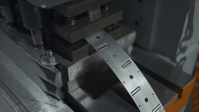 A large industrial punch press forming sheet metal parts. Creative. Close up of sheet metal stamping machine.