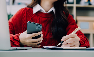 Asian Business woman using calculator and laptop for doing math finance on an office desk, tax, report, accounting, statistics, and analytical research concept