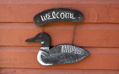 Cabin welcome sign with an artistically painted  wooden loon bird. Danbury Wisconsin WI USA