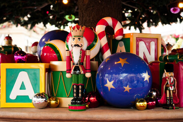 Nutcracker Soldier toy, drum, candy cane, star ball, alphabet block and metallic ornaments decoration with big pine tree celebrate in festive season at the Merry Xmas carnival - obrazy, fototapety, plakaty
