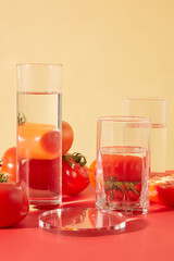 Close-up of transparent glasses of water displayed on the table along with juicy red tomatoes. Tomatoes contain compounds that help shrink pores, treat acne, soothe sunburns and brighten skin tone.