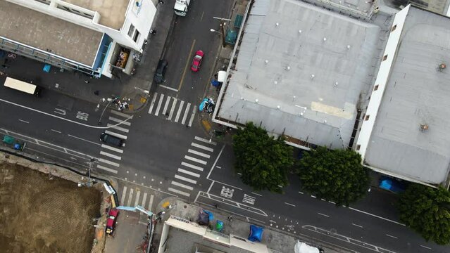 Aerial view of traffic in middle of unhoused people on the streets of Skid Row, LA