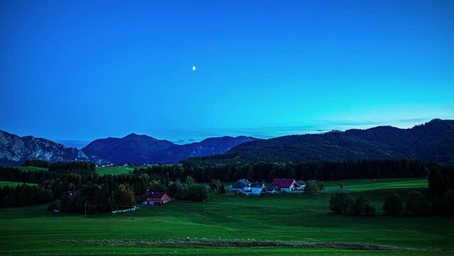 Moon rising over a countryside farm in the Austrian alps - time lapse