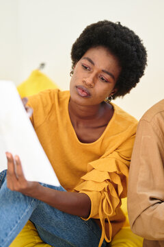 Businesswoman Showing A Project. Black Woman, With Afro Look And Acne On Her Face Showing Documents To Her Coworker