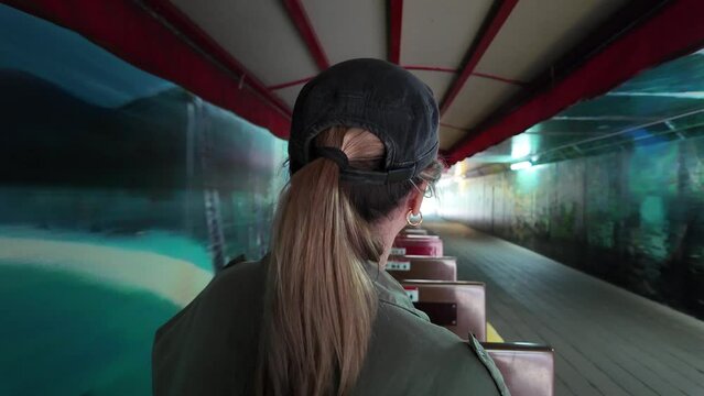Women riding on a small scenic train as it travels through a tunnel painted in murals.