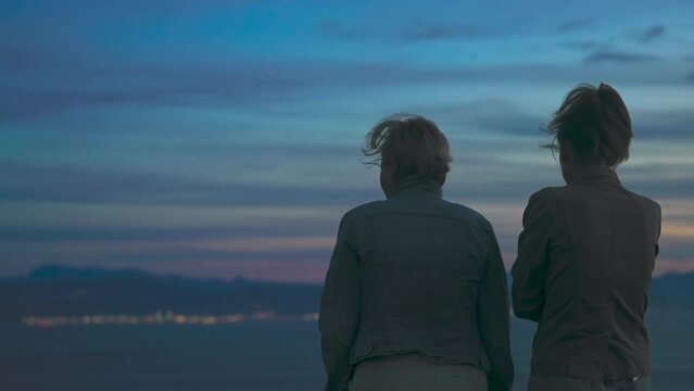 Medium Shot of women sightseeing on the strait of Gibraltar of after sundown