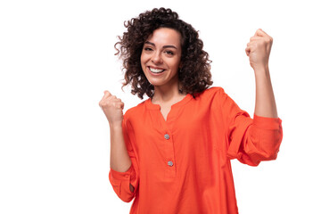 young successful caucasian business woman with curly hairstyle dressed in orange shirt
