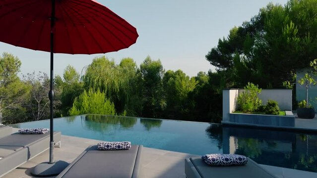 Slow dolly past sunlounger at a private pool in the garden of a villa in St Gely du Fresc