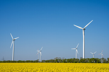 Wind turbines and a field of yellow rapeseed seen in Germany