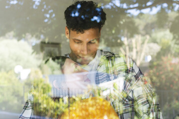 Happy diverse couple embracing and standing by window at home, copy space