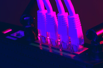 Cables plugged in a Wi-Fi router on dark background