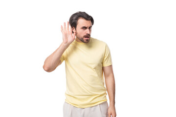 Fototapeta premium caucasian surprised brutal charming guy with a beard dressed in a summer t-shirt on a white background with copy space