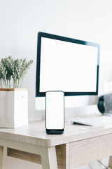 Mockup of computer and mobile phone with white blank screen on office table 