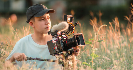 Teenage boy operating camera in the movie industry. new content creator, young filmmaker.