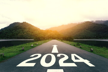 The new year 2024 or straightforward concept. Text 2024 written on the asphalt road at sunset....