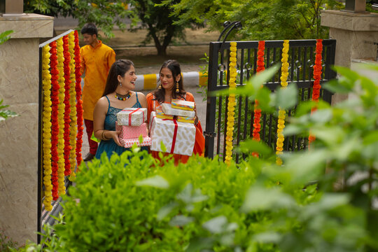 Two sisters carrying Diwali gifts after shopping 
