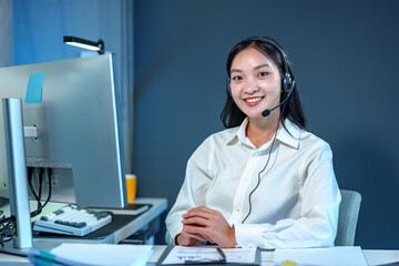 Young Asian call center woman working in a company. Attractive office worker sitting at a desk,...
