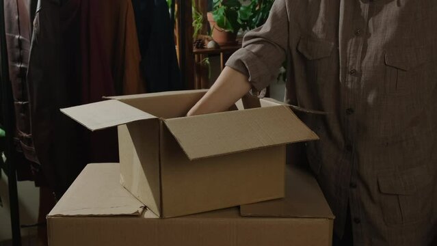 Movement concept. Young woman unpacking moving boxes.