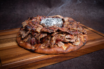 Turkish Iskender Shawarma Meat or beef or chicken with Charcoal in the center and sauces around. Cook fries grilled meat shawarma. Hot fresh delicious kebabs - a fine selection of street food.