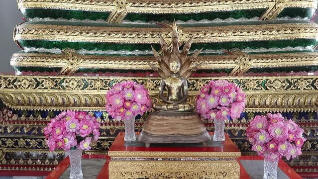 Gilded saturday Buddha protected by naga multi-headed snake at Wat Pho, Bangkok