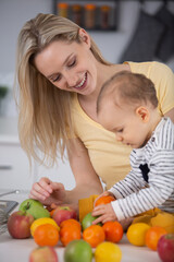happy mother and baby and fruits on the table