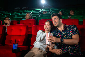 Asian couple sweet and watching comedy movie together in romantic theater