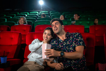 Asian couple sweet and watching comedy movie together in romantic theater