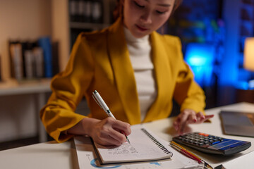 Asian businesswoman working at the office Preparing a report, calculating balance, auditing...