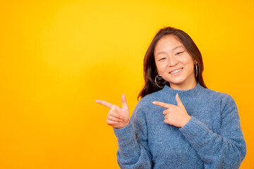 Chinese woman pointing to the side in a blank space