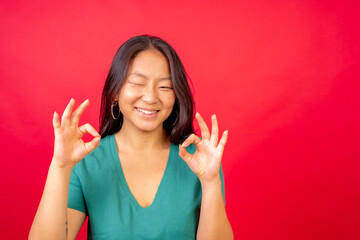 Chinese woman gesturing ok with hands and winking - obrazy, fototapety, plakaty