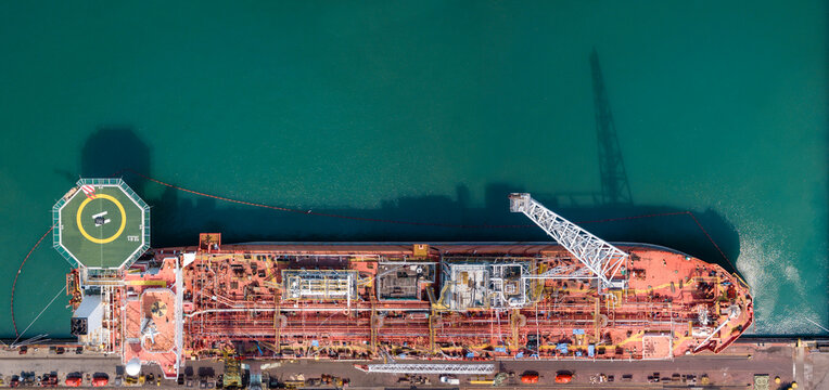 Cargo tanker ship marine vessel docking on oversea berth mooring platform for petroleum and crude oil industry from top view angle