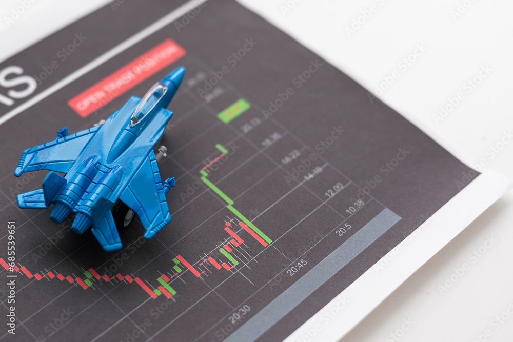 Poster tablet with stock data on table and a toy airplane