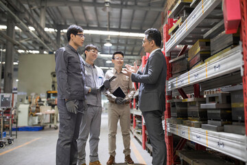 Businessman and engineers talking in the factory