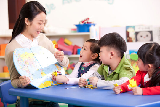 Female teacher teaching kindergarten children geography
