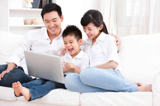 Family using laptop in sofa
