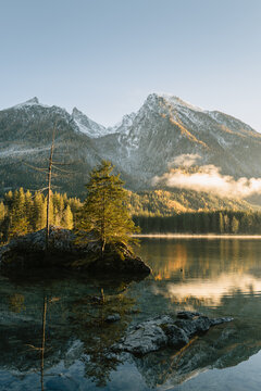 kleine Insel auf dem Hintersee bei Sonnenuntergang mit dem verschneiten Hochkalter im Herbst