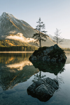 kleine Insel auf dem Hintersee bei Sonnenuntergang mit dem verschneiten Hochkalter im Herbst