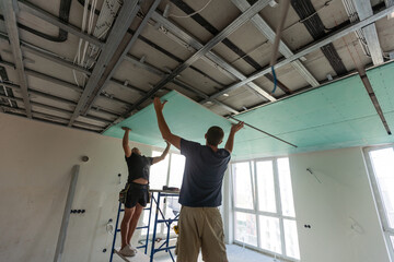 Construction worker ceiling work installation