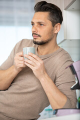 relaxed young man drink first morning coffee at home