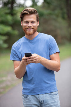 man using a smart phone outdoors in a park