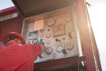 The operator in fully PPE uniform is operating on control panel of the liquid nitrogen convertor...
