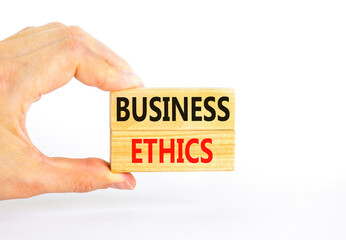 Business ethics symbol. Concept words Business ethics on beautiful wooden blocks. Beautiful white table white background. Businessman hand. Business ethics concept. Copy space.