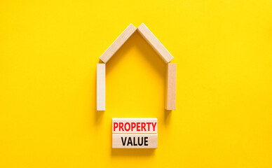 Fototapeta na wymiar Property value symbol. Concept words Property value on beautiful wooden blocks. Beautiful yellow table yellow background. House model. Business property value concept. Copy space.