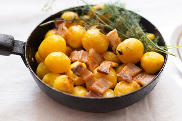 Delicious freshly cooked fried new potatoes with bacon served in a frying pan