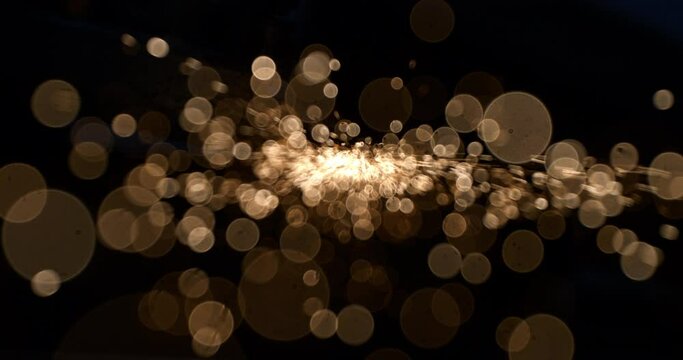 Super slow motion macro of abstract bokeh flying sparks glitter lights isolated on dark background.