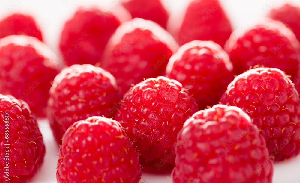 Wall mural Handful of raspberry berries on white background