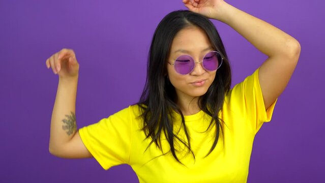 Chinese woman with sunglasses dancing and smiling