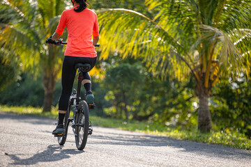 Obraz premium Riding folding bike on tropical road