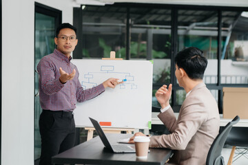 Businessman leading team meeting and using tablet and laptop computer with financial in co working...