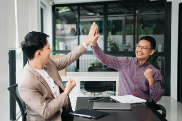Businessman leading team meeting and using tablet and laptop computer with financial in co working...